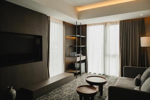 a living room with a couch and a tv at Manon Boutique Hotel Kota Lama Semarang in Semarang
