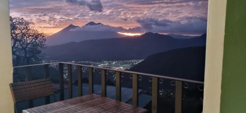 a balcony with a table and a view of a mountain at Hotel El Tambor OASIS Antigua Guatemala in Antigua Guatemala