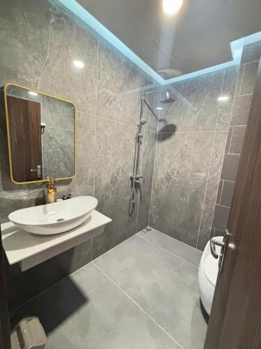 a bathroom with a sink and a shower and a toilet at Times Hotel in Trảng Bàng