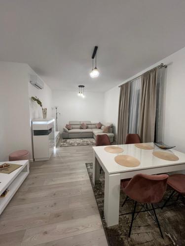 a white living room with a white table and chairs at Ioanic Modern Apartment with Parking in Ploieşti