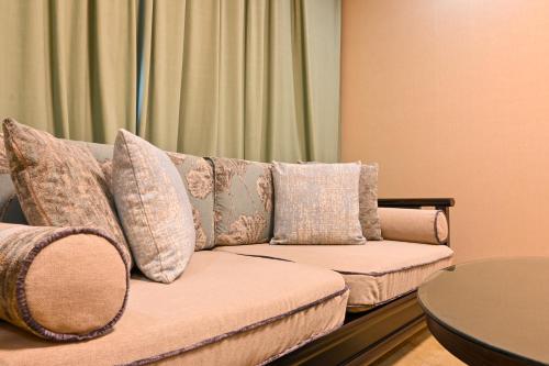 a couch with pillows sitting in a living room at Dunhuang Hotel in Dunhuang
