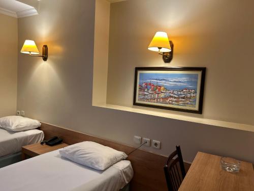 イスタンブールにあるHaydarpasa Hotelのベッド2台、テーブル、照明が備わるホテルルームです。