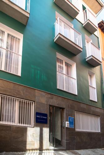 a green building with balconies on the side of it at Apartamentos Campo Del Príncipe in Granada