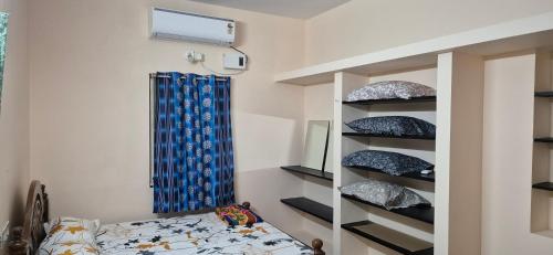 a bedroom with a bunk bed and a blue curtain at Arunachalam Home Stay in Tiruchchendūr
