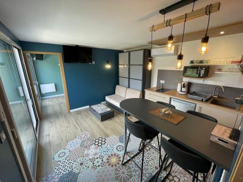 une cuisine et un salon avec une table et des chaises dans l'établissement Neuf, indépendant avec terrasse et vue montagnes !, à Cruet