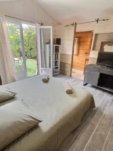 une chambre avec un grand lit et une grande fenêtre dans l'établissement Tim by Terrys Homes, à Hyères