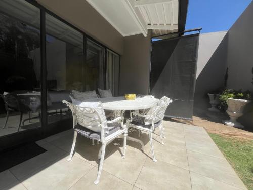 a white table and chairs on a patio at La Vida Luka - Luxury Guesthouse in Pretoria