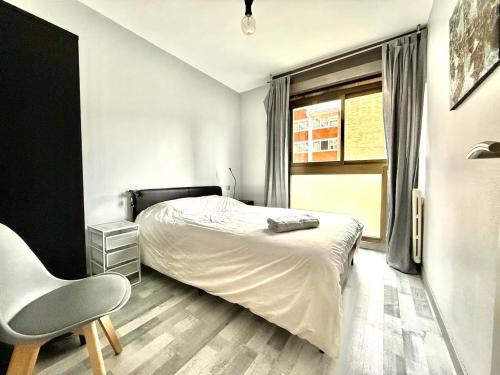 une chambre avec un lit, une chaise et une fenêtre dans l'établissement Vidal by Yumē, à Toulouse