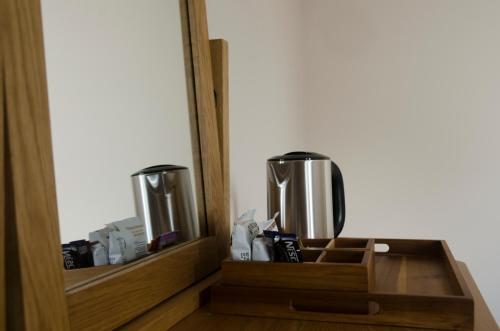 a wooden drawer with two silver trash cans in a room at The Sun Inn in Penrith