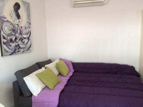 a bedroom with a purple bed and a couch at El Atico Del Gran Capitan in Córdoba