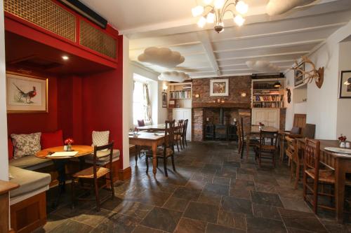 Un restaurante con mesas y sillas y una chimenea. en Notley Arms Inn Exmoor National Park, en Elworthy