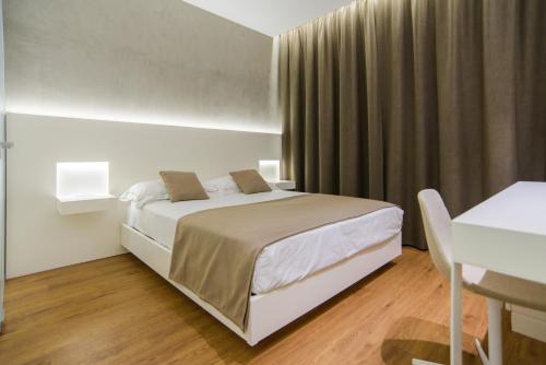 a white bedroom with a bed and a desk at Best Western Hotel Biri in Padova