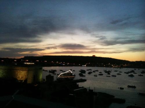 a group of boats in a harbor at sunset at Mel 4 Seaview 2bed Ph In Ghadira By Homely in Mellieħa