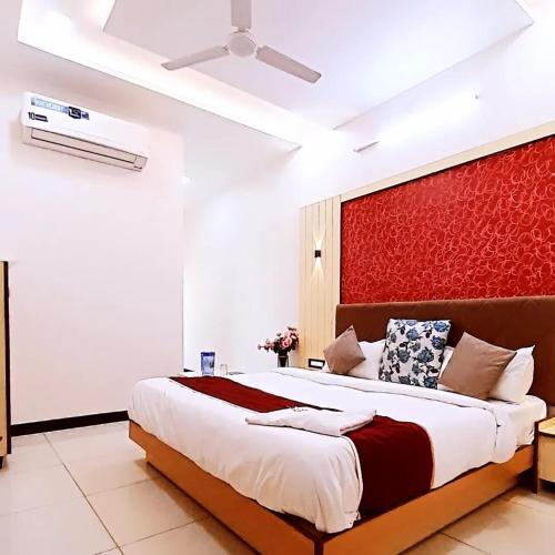 Un dormitorio con una cama grande con una pared roja. en Hotel Sun Palace, en Udaipur