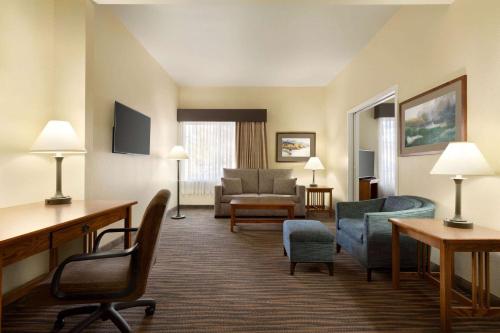 a hotel room with chairs and a living room at Wingate by Wyndham Denver Tech Center in Greenwood Village