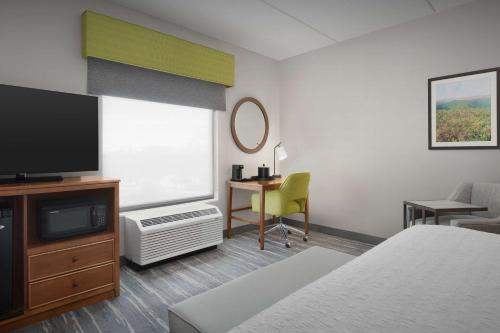 a hotel room with a bed and a tv and a desk at Hampton Inn and Suites Lynchburg in Lynchburg