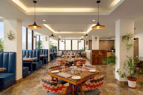 a dining room with tables and blue chairs at Days Inn by Wyndham Gangtok Tadong in Gangtok