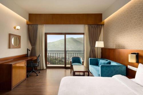 a hotel room with a bed and a desk and a window at Days Inn by Wyndham Gangtok Tadong in Gangtok
