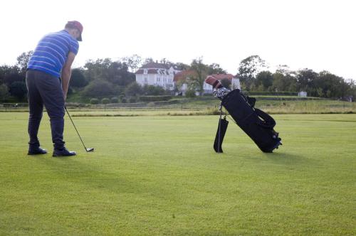 a man is playing golf on a golf course at Tofta Herrgård in Lycke
