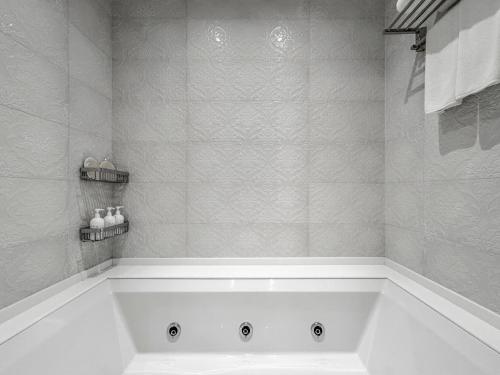 a white bath tub in a bathroom with a shower at Ena Boutique Hotel & Residences in Bodrum City