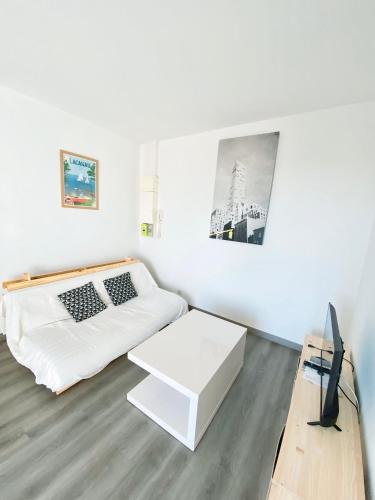 un salon blanc avec un canapé et une table dans l'établissement Appartement confort&shiny Talence - WIFI - Parking, à Talence