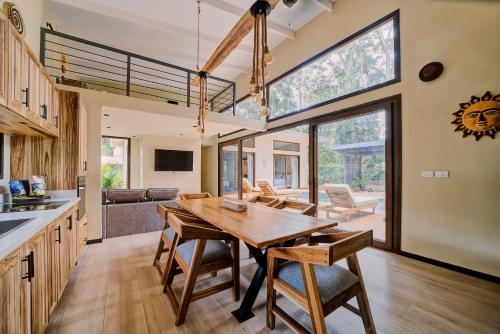 a kitchen and dining room with a wooden table and chairs at Villas Roca del Caribe in Puerto Viejo