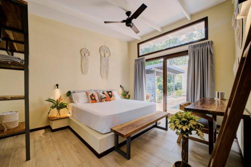 a bedroom with a large white bed and a window at Villas Roca del Caribe in Puerto Viejo