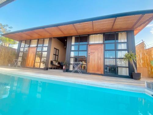 a house with a pool in front of it at Casa nel Mezzo - A Pineapple Farm Escapee in Ulot