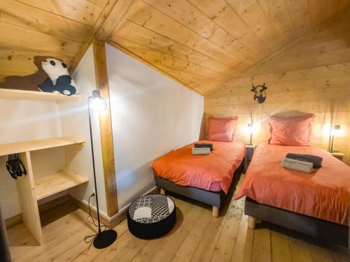 - une chambre avec 2 lits dans une cabane en bois dans l'établissement Chalet Adele - Appartement 6 personnes situé en bord de piste St Martin de Belleville MAE-8204, à Saint-Martin-de-Belleville