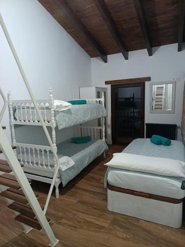 a bedroom with two bunk beds and a wooden floor at Rural Norte in Bañugues