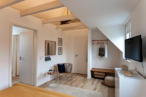 a living room with a flat screen tv on the wall at Lykke Lys in Heiligenhafen