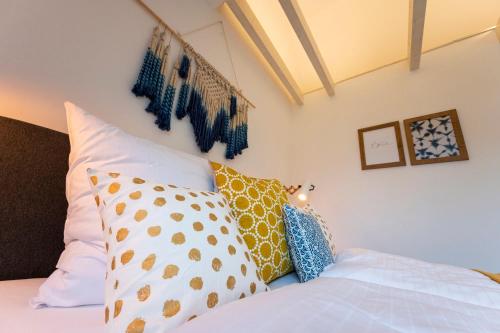 a bed with many pillows on it at Lykke Lys in Heiligenhafen