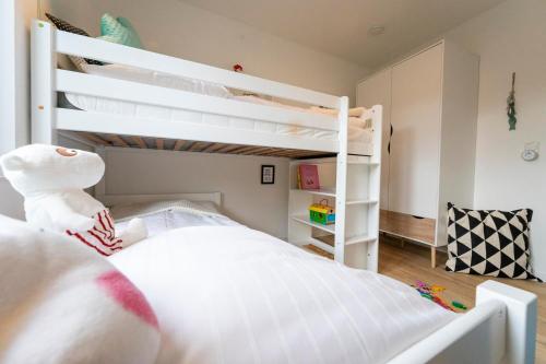 a bedroom with two bunk beds and a stuffed animal at Lykke Lys in Heiligenhafen