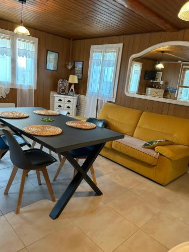 un salon avec une table et un canapé dans l'établissement Maison confort & jardin à Saint-Pierre-d'Oléron, à Saint-Pierre-dʼOléron