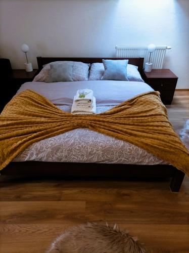 a bedroom with a bed with a blanket on it at Penzión Turzov in Gelnica