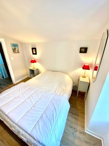 - une chambre avec un lit blanc et deux lampes dans l'établissement Maison les lauriers roses, à Saint-Georges-de-Didonne