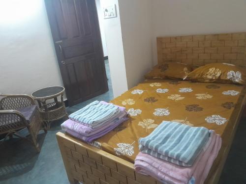 a bedroom with a bed with towels on it at Travellers Homestay in Silchar