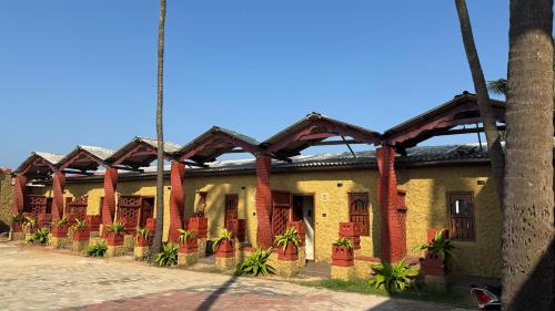 a building with red brick pillars and plants on it at Vistara Beach Resort Malpe - Udupi in Udiyāvara