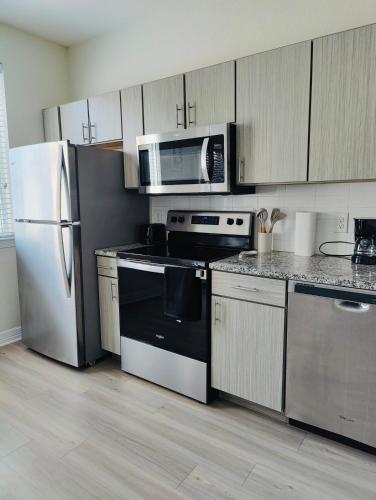 a kitchen with a refrigerator and a microwave at Stylish 1BHK, 1 Bath in Cedar Park, Austin, TX in Cedar Park