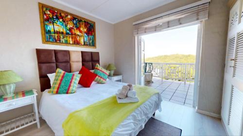 a bedroom with a large bed and a balcony at Caribbean Estates -46 Montego Bay in Port Edward