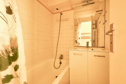 une salle de bain avec une baignoire, un lavabo et un miroir dans l'établissement Résidence Artigalas - Studio avec balcon et parking couvert dans le contre de Barèges MAE-8524, à Barèges