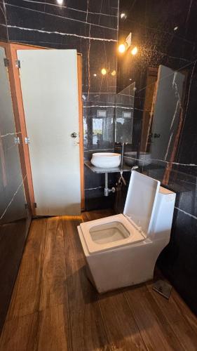 a bathroom with a toilet and a sink at Vistara Beach Resort Malpe - Udupi in Udiyāvara