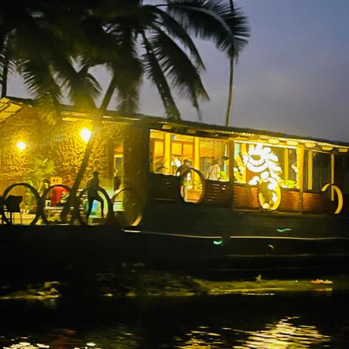 a boat in the water at night with palm trees at Vistara Beach Resort Malpe - Udupi in Udiyāvara
