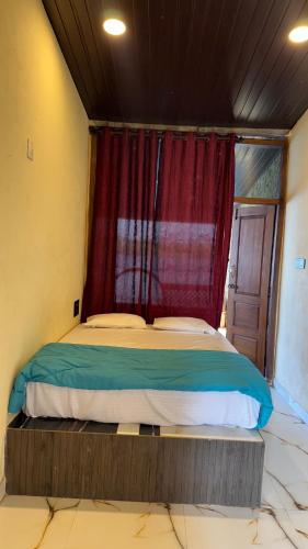 a bedroom with a bed with a red curtain at Vistara Beach Resort Malpe - Udupi in Udiyāvara