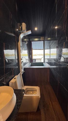 a bathroom with a toilet and a tub in it at Vistara Beach Resort Malpe - Udupi in Udiyāvara