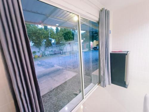 a sliding glass door with a view of a yard at Saan Rak Resort in Prachuap Khiri Khan