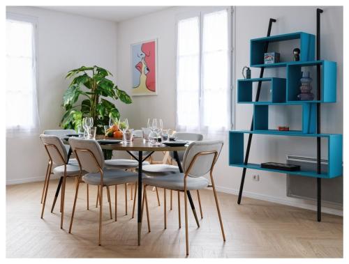une table à manger avec des chaises et une étagère bleue dans l'établissement Super appart entre Disney et Paris avec parking !, à Bailly-Romainvilliers