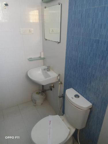 a bathroom with a white toilet and a sink at Hotel Pandian in Chennai