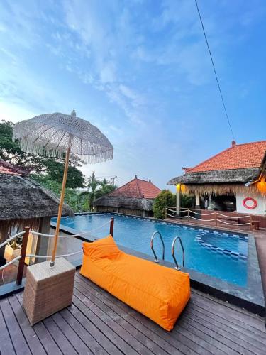 an umbrella sitting on a deck next to a swimming pool at Simpang Inn Hostel in Nusa Penida
