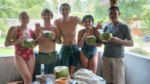 a group of people holding up green coconuts at Medya homestay in Pulau Sarang